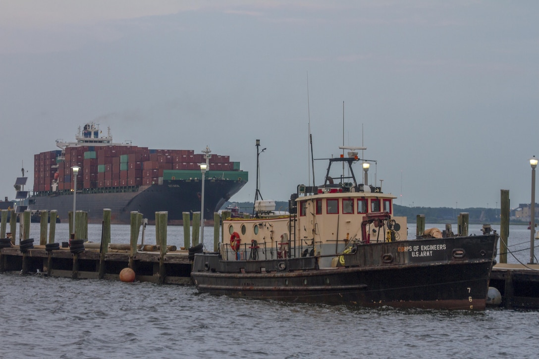 NORFOLK, Va. -- The Norfolk District debris removal vessel MOBJACK sits moored at the district's dock as the Container Ship Octavia arrives at the Portsmouth Marine Terminal across the Elizabeth River in Portsmouth, Virginia, July 28, 2017. The MOBJACK's mission is to patrol the federal navigation channels  removing debris, which could damage ships, like the Octavia, as they navigate to and from the various port facilities in the Hampton Roads region of Virginia. (U.S. Army photo/Patrick Bloodgood)