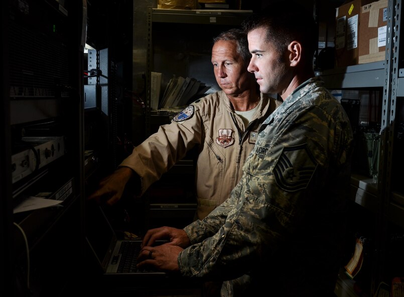 Master Sgt. Kyle Tschida, a Joint Interface Control cell watch officer with the 609th Air Operations Center, right, and Lt. Col. Terry Brennan, deputy U.S. Air Forces Central Command JIC officer, review datalink software changes July 21, 2017, at the Combined Air Operations Center on Al Udeid Air Base, Qatar. Brennan led a team that re-engineered theater data link architecture and provided reliable connectivity and responsive data link message traffic for the warfighter. (U.S. Air Force photo by Staff Sgt. Alexander Riedel)