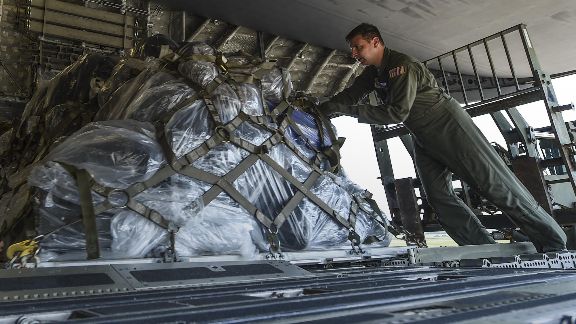 A loadmaster from the 15th Airlift Squadron at Joint Base Charleston, S.C. loads cargo onto a C-17 July 23, 2017, at Little Rock Air Force Base, Ark. Eight Little Rock C-130Js will travel alongside the C-17 aircrew to participate in Mobility Guardian 2017, a massive joint exercise at Joint Base Lewis-McChord, Wash. (U.S. Air Force photo by Staff Sgt. Harry Brexel)