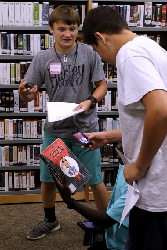 Craven County high school students participate in a scavenger hunt during a Stand Out Leaders in Training teen leadership day aboard Marine Corps Air Station Cherry Point, N.C., July 25, 2017. The young adults explored the Warrior library during a scavenger hunt that taught them what resources the library has to offer. The Cherry Point School Liaison Program hosted the event to actively engage local school-age children in leadership and team-building exercises aboard the installation. (U.S. Marine Corps photo by Cpl. Jason Jimenez/ Released)