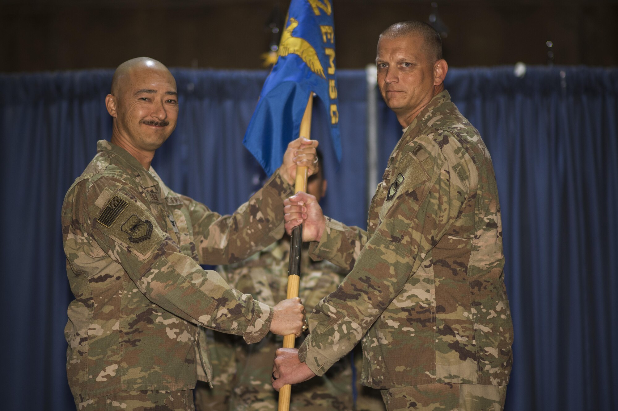Col. Christopher K. Fuller, 332nd Expeditionary Mission Support Group commander, left, passes the guidon to Lt. Col. Chad S. Sitzmann, during the 332nd Expeditionary Logistics Readiness Squadron change of command ceremony July 28, 2017, in Southwest Asia. The passing of a guidon symbolizes a unit’s transfer of command. (U.S. Air Force photo/Senior Airman Damon Kasberg)