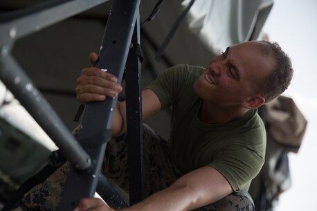 U.S. Marine Lance Cpl. Devin Crain, a heavy equipment operator with Combat Logistics Battalion 5 (CLB-5), Combat Logistics Regiment 1, 1st Marine Logistics Group, pulls a pole into place on the Marine Corps Mountain Warfare Training Center Bridgeport, Calif., June 14, 2017. CLB-5 supports the 2d Battalion, 8th Marine Regiment, 2d Marine Division, logistically by tackling the technical aspects of mountainous and cold weather operations by providing them chow, water, and fuel. (U.S. Marine Corps photo by Lance Cpl. Timothy Shoemaker)