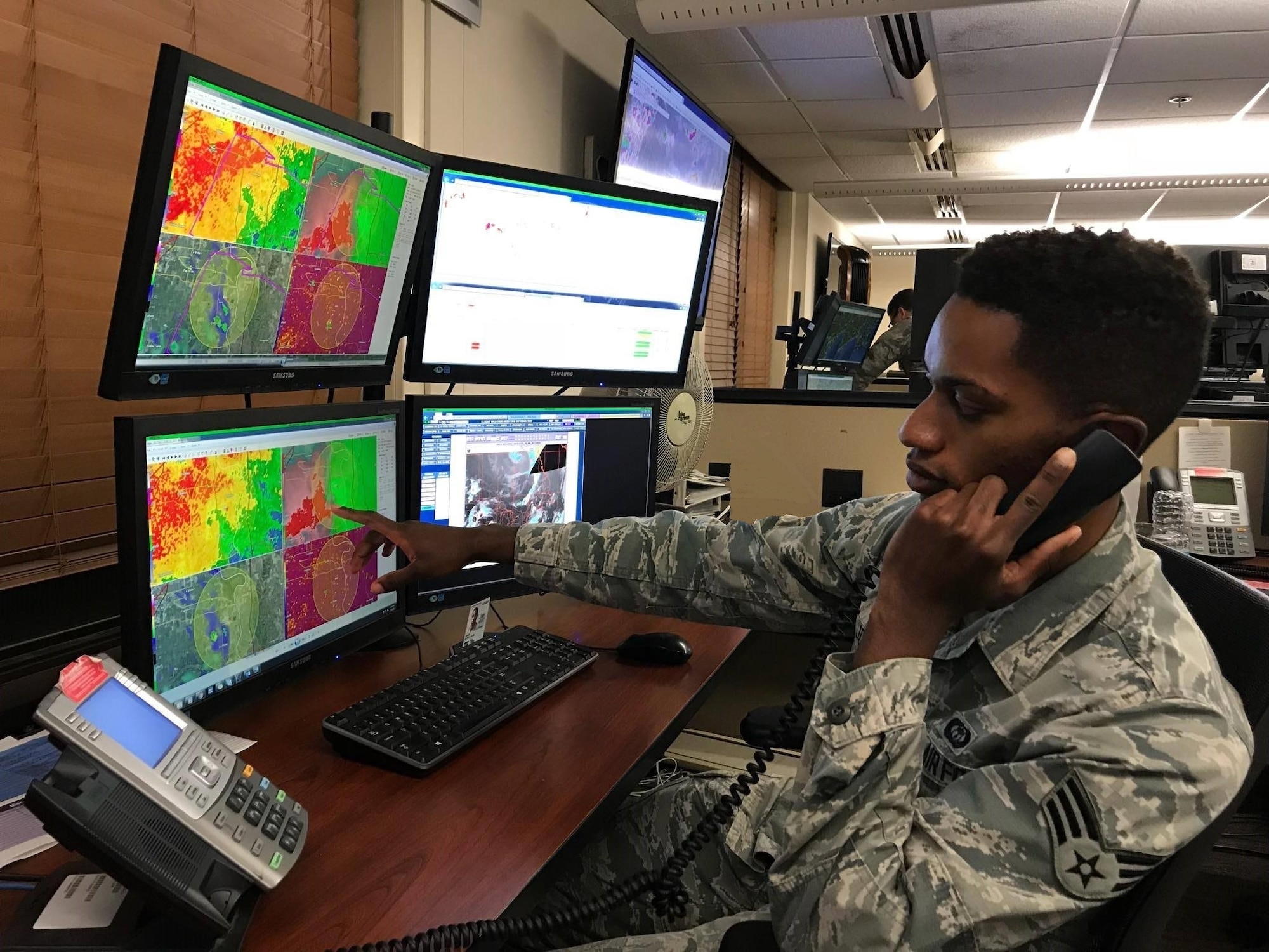 Senior Airman Quincy Jones, 15th Operational Weather Squadron weather forecaster, points to weather patterns on screen at Scott Air Force Base, Ill. (courtesy photo)
