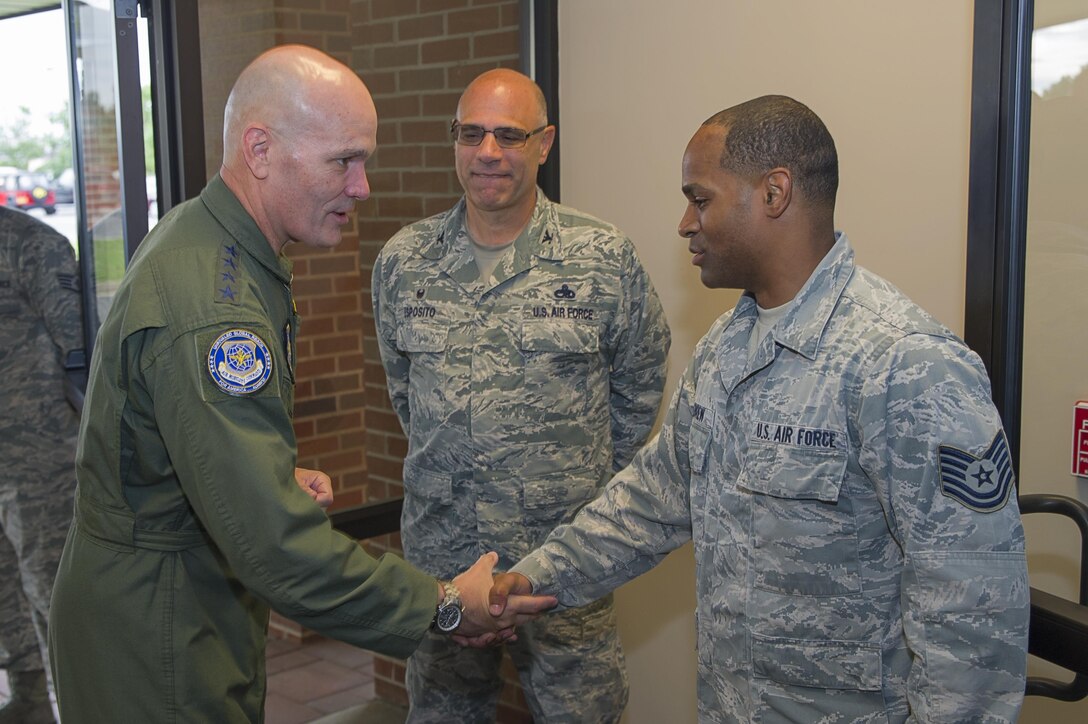 Gen. Carlton D. Everhart II, Air Mobility Command commander coins Tech. Sgt. Michael Killebrew, 714th Aircraft Maintenance Squadron flying crew chief, for being a star performer within the 514th Air Mobility Wing. Everhart and Maj. Gen. Brian Dominguez, AMC mobilization assistant to the commander visited the Freedom Wing where they experienced the wing's rapid global mobility capabilities July 25-26. (U.S. Air Force photo by Christian DeLuca/released)