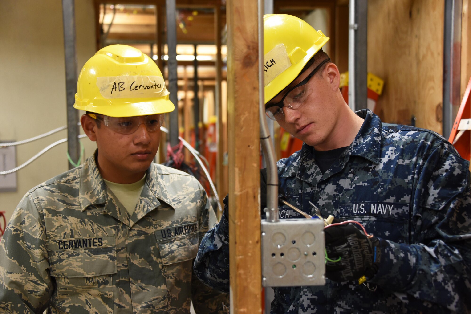 Airman Ángel Cervantes and Seaman William Dietrich, 366th Training Squadron electrical systems apprentice course students check the power on a three-way switch at Sheppard Air Force Base, Texas. This course provides initial training for students to perform installation and maintenance duties of interior electrical systems. (U.S. Air Force photo/Liz H. Colunga)