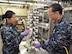 Lt.s Dan Xu (left), a Navy Research Biochemist, and Joshua Roaf (right), a naval surface warfare officer and graduate intern on site at the Naval Medical Research Unit - Dayton as part of his master's program in toxicology at The University of North Carolina at Chapel Hill, work to draw a filter sample for contaminant verification of particulate matter during a test at NAMRU-D's Environmental Health Effects Laboratory July 25 (U.S. Air Force photo/Bryan Ripple).