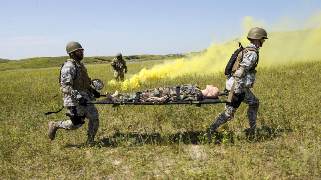 Air Force Staff Sgt. LaMitchell Primm, left, and Airman 1st Class Christopher Novotny carry a simulated battle casualty on a litter during training at Camp Gilbert C. Grafton near Devils Lake, N.D., July 20, 2017. Both are assigned to the North Dakota Air National Guard’s 119th Medical Group. Air National Guard photo by Senior Master Sgt. David H. Lipp