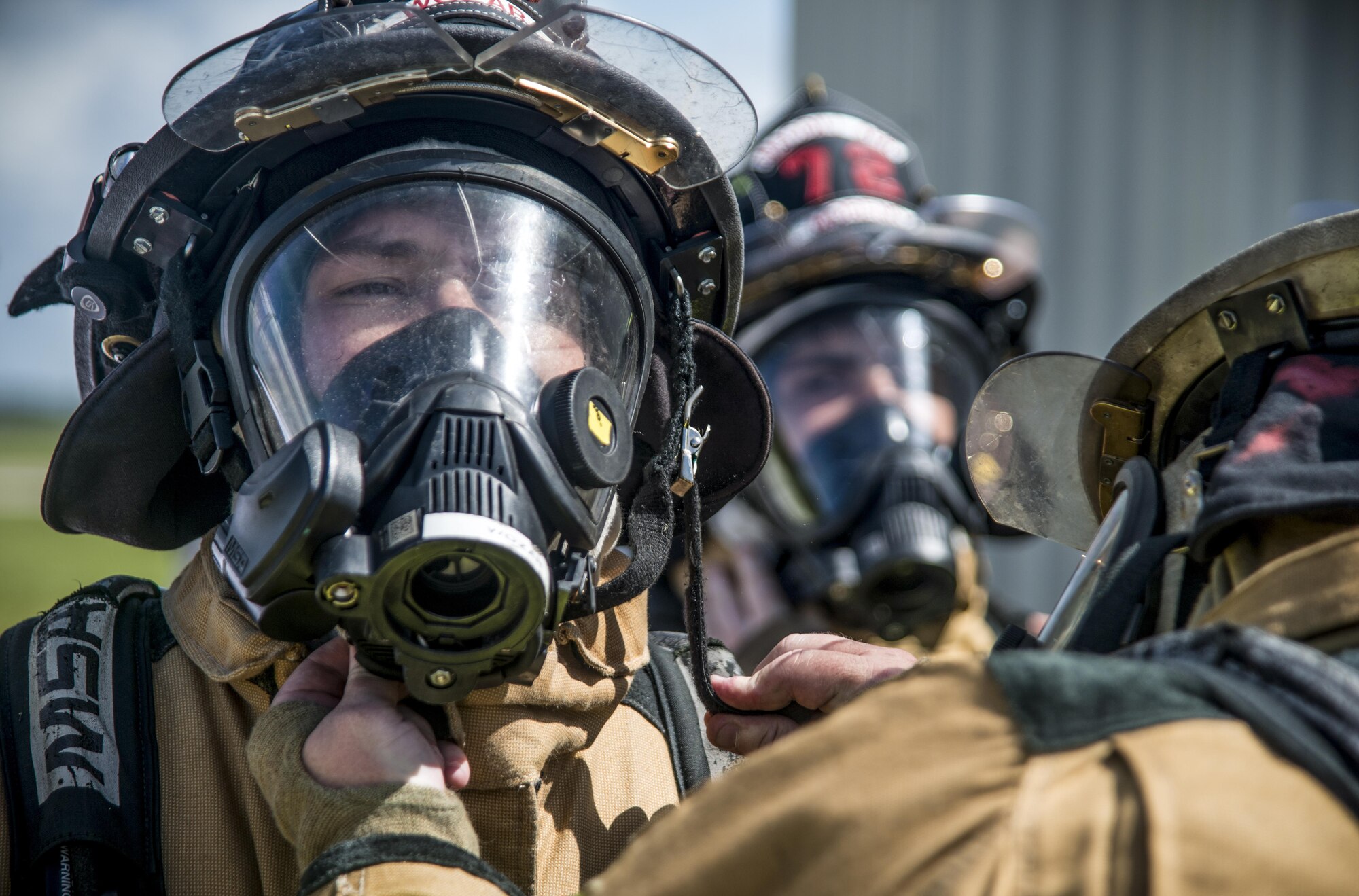 U.S. Air Force Staff Sgt. Joshua Wozar, a fire protection crew chief assigned to the 6th Civil Engineer Squadron, gets his mask properly sealed by a fellow firefighter before a live-burn training scenario at MacDill Air Force Base, Fla., July 24, 2017. The exercise took place inside a structure to help demonstrate the behavior of a burning building and to allow the firefighters an opportunity for hands-on training. (U.S. Air Force photo by Airman 1st Class Adam R. Shanks)