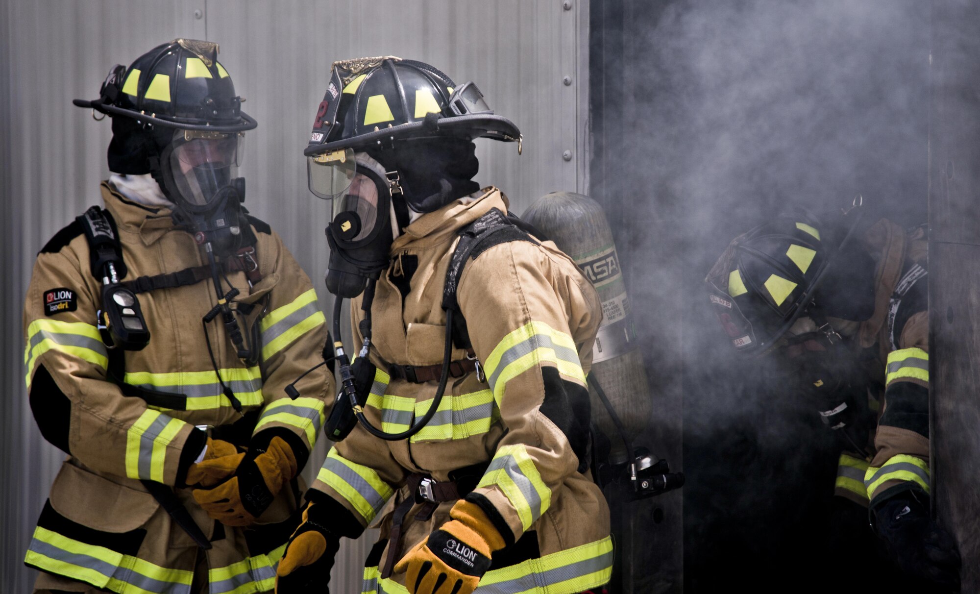 U.S. Air Force firefighters assigned to the 6th Civil Engineer Squadron exit a training building during a structural, live-burn exercise at MacDill Air Force Base, Fla., July 24, 2017. Airmen were trained on the behavior of a live fire inside a building and how to safely extinguish it. (U.S. Air Force photo by Airman 1st Class Adam R. Shanks)