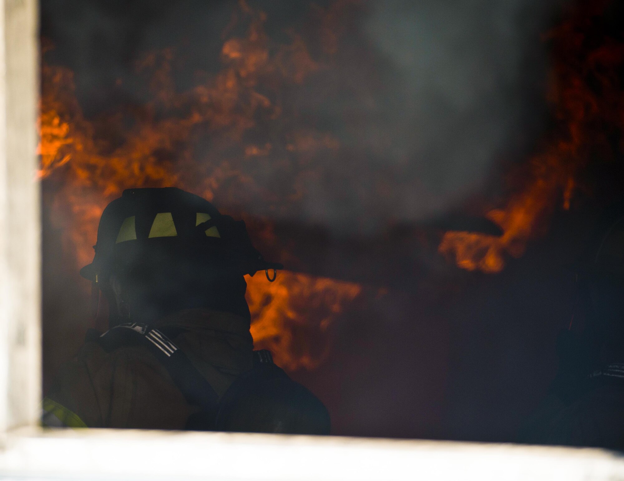 A U.S. Air Force firefighter assigned to the 6th Civil Engineer Squadron prepares to extinguish a training fire at MacDill Air Force Base, Fla., July 24, 2017. Before the flame was extinguished, firefighters were trained on a fire’s behavior inside a building and the precautions they should take. (U.S. Air Force photo by Airman 1st Class Adam R. Shanks)