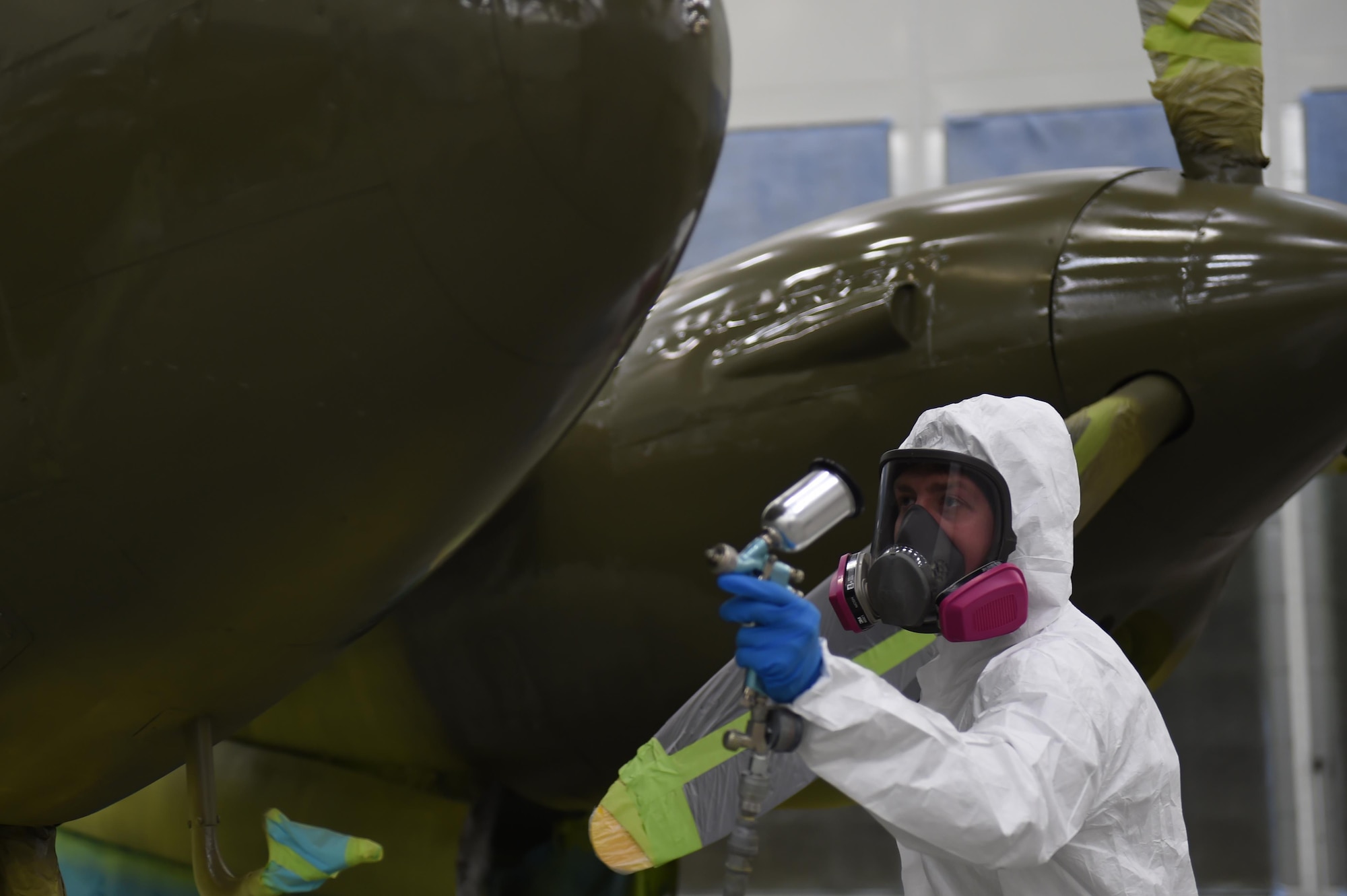 Air Force Senior Airman Kurtis Steinecke paints a P-38G Lightning inside Hangar 21before it can be returned to the Heritage Park at Joint Base Elmendorf-Richardson, Alaska, July 17, 2017. Steinecke is one of the two Airmen who are putting the final touches on the aircraft. 
