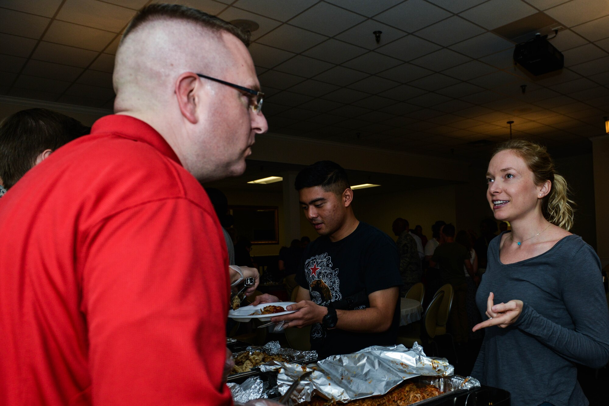 An attendee of the Deployed Family Dinner speaks with a volunteer serving food in a buffet line at the Carolina Skies Club and Conference Center at Shaw Air Force Base, S.C., July 24, 2017. Churches from the local area provided food during the dinner for the families of deployed service members. (U.S. Air Force photo by Airman 1st Class Destinee Sweeney)