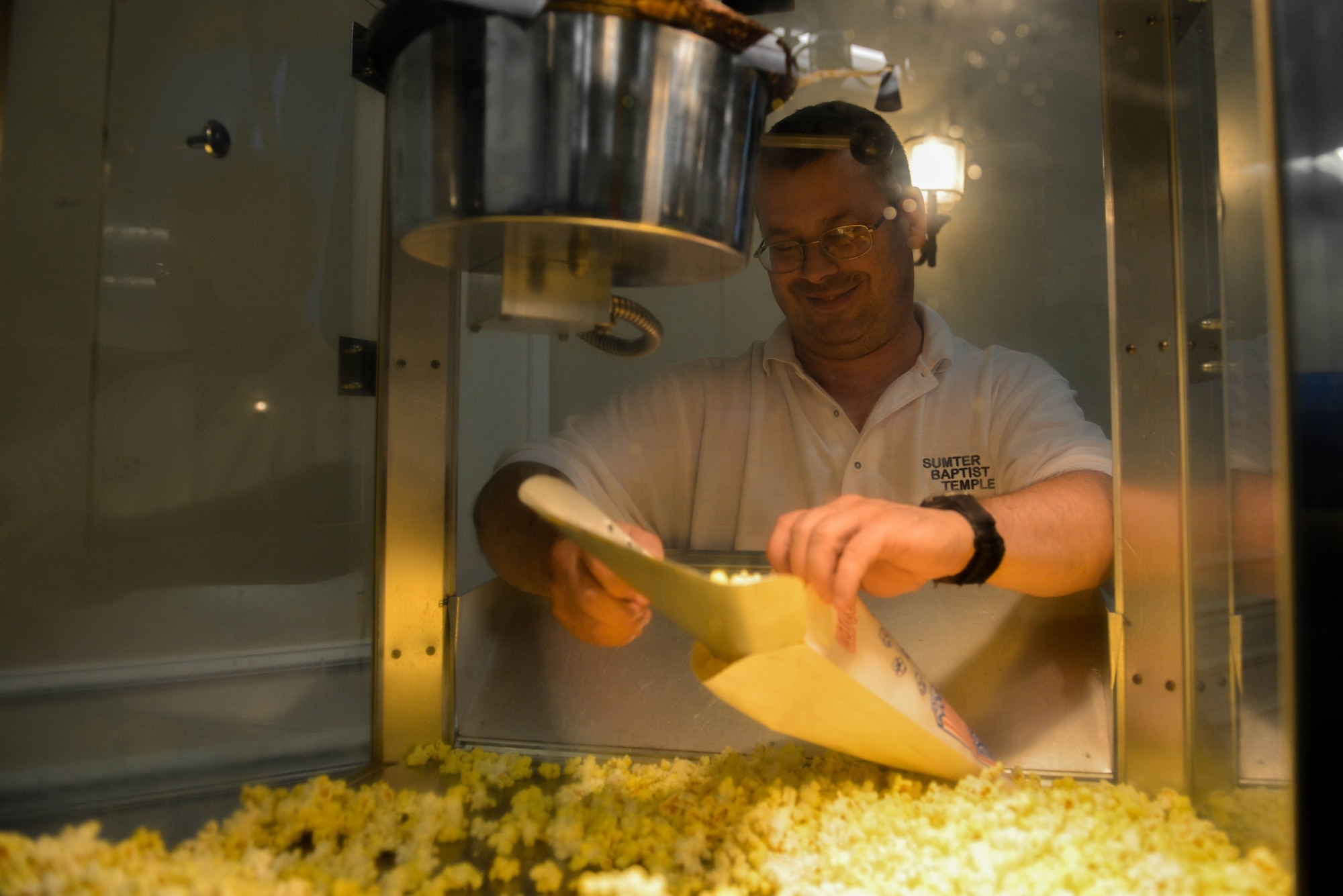 U.S. Air Force Master Sgt. Richard Essigmann, 20th Equipment Maintenance Squadron programs noncommissioned officer in charge and volunteer, scoops popcorn into bags during a Deployed Family Dinner at the Carolina Skies Club and Conference Center at Shaw Air Force Base, S.C., July 24, 2017. The Deployed Family Dinner provided an opportunity for the families of deployed service members to socialize, build resiliency and share a meal together. (U.S. Air Force photo by Airman 1st Class Destinee Sweeney)