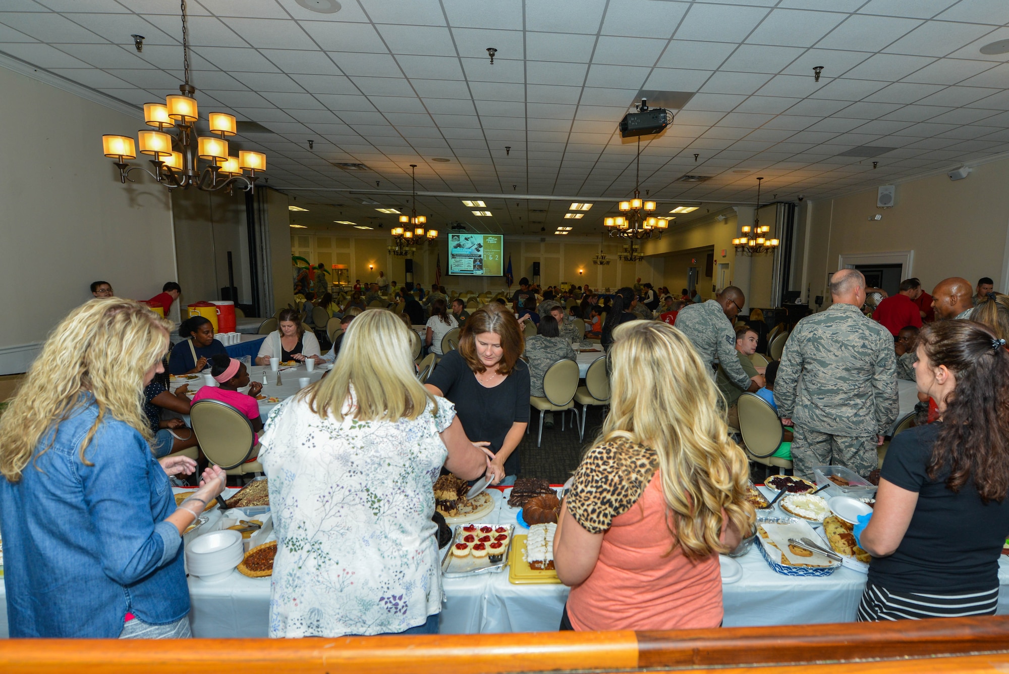 Volunteers serve food during a Deployed Family Dinner at the Carolina Skies Club and Conference Center at Shaw Air Force Base, S.C., July 24, 2017. During the dinner, 25 volunteers from a local church and seven military volunteers provided food and service for more than 60 family members. (U.S. Air Force photo by Airman 1st Class Destinee Sweeney)