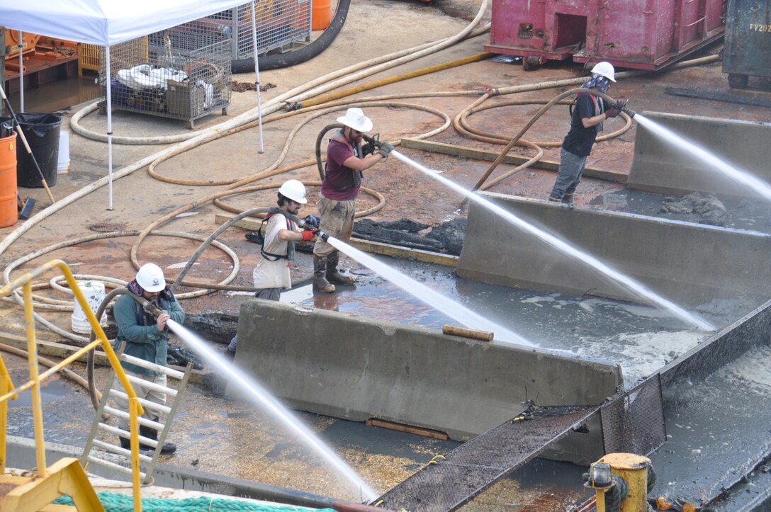 Archaeologists and other crew members use pressure hoses to separate potentially significant artifacts from river muck during the recovery of the Civil War ironclad, CSS Georgia. Crews needed to remove the relic in order to allow the deepening of the Savannah harbor. In addition to smaller objects recovered through this high-pressure screening, crews also also recovered large casemates made of railroad rails used to armor the warship. The Savannah Harbor Expansion Project (SHEP) will deepen America's fourth busiest container port (second busiest on the East Coast) from its current 42-foot depth to 47 feet deep. This will allow newer, larger container vessels to call on the port with fewer tidal restrictions and with heavier loads. (U.S. Army Corps of Engineers photo by Billy Birdwell.)