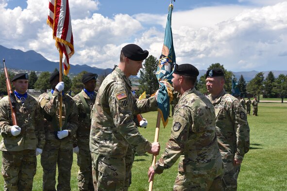 Col. Rick Zellmann, commander, 1st Space Brigade, U.S. Army Space and Missile Defense Command/Army Forces Strategic Command, passes the 1st Space Battalion colors to Lt. Col. Donald Brooks. The change of command from outgoing Lt. Col. Bryan Shrank to Brooks took place July 21, 2017, at Fort Carson, Colorado. (U.S. Army photo by Dottie White)
