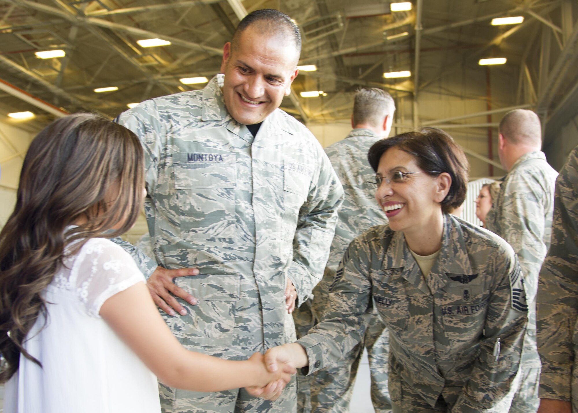 Chief Master Sgt. Ericka Kelly, Air Force Reserve Command command chief, shakes hands with Chief Master Sgt. Gabriel Montoya’s daughter, Ciara, 10, July 15, 2017, at Beale Air Force Base, California. Montoya, 940th Maintenance Group superintendent, was promoted to Chief during a ceremony following the AFRC all-ranks all-call. (U.S. Air Force photo by Senior Airman Tara R. Abrahams)