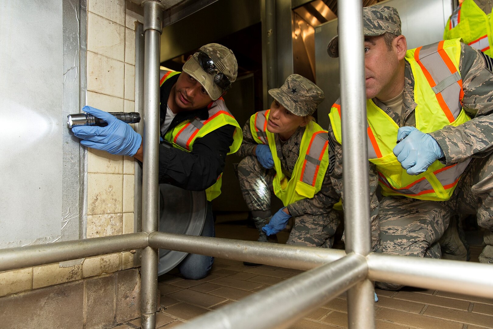 From left to right. Jorge Ortiz, 502nd Civil Engineer Squadron Pest Management pest control technician, Brig. Gen. Heather Pringle, 502nd Air Base Wing and Joint Base San Antonio commander, and Chief Master Sgt. Kristopher K. Berg, 502nd ABW and JBSA command chief, survey a dining facility at JBSA-Lackland, Texas, July 20, 2017. Pest control technicians use long term solutions like bait to ensure insect and rodent population never gets out of control.