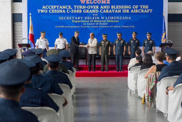 Chief of Joint U.S. Military Assistance Group Philippines Col. Ernest Lee, Deputy Commander of U.S. Pacific Command Lt. Gen. Bryan Fenton, U.S. Ambassador to the Philippines Sung Y. Kim, Secretary of National Defense Delfin N. Lorenzana, Chief of Staff of the Armed Forces of the Philippines General  Eduardo Año, Commanding General of the Philippine Air Force Lt. Gen. Edgar Fallorina, Wing Commander of the 420th Supply Wing Brig. Gen. Arthur B. Blanca, and Commander of 300th Air Intelligence and Security Group Col. Gleen Albert C. Laguardia, ceremonially transfer paperwork during the turnover and blessing ceremony of two Cessna 208B aircraft from the U.S. to the Philippine Air Force at Villamor Air Base in Pasay City.