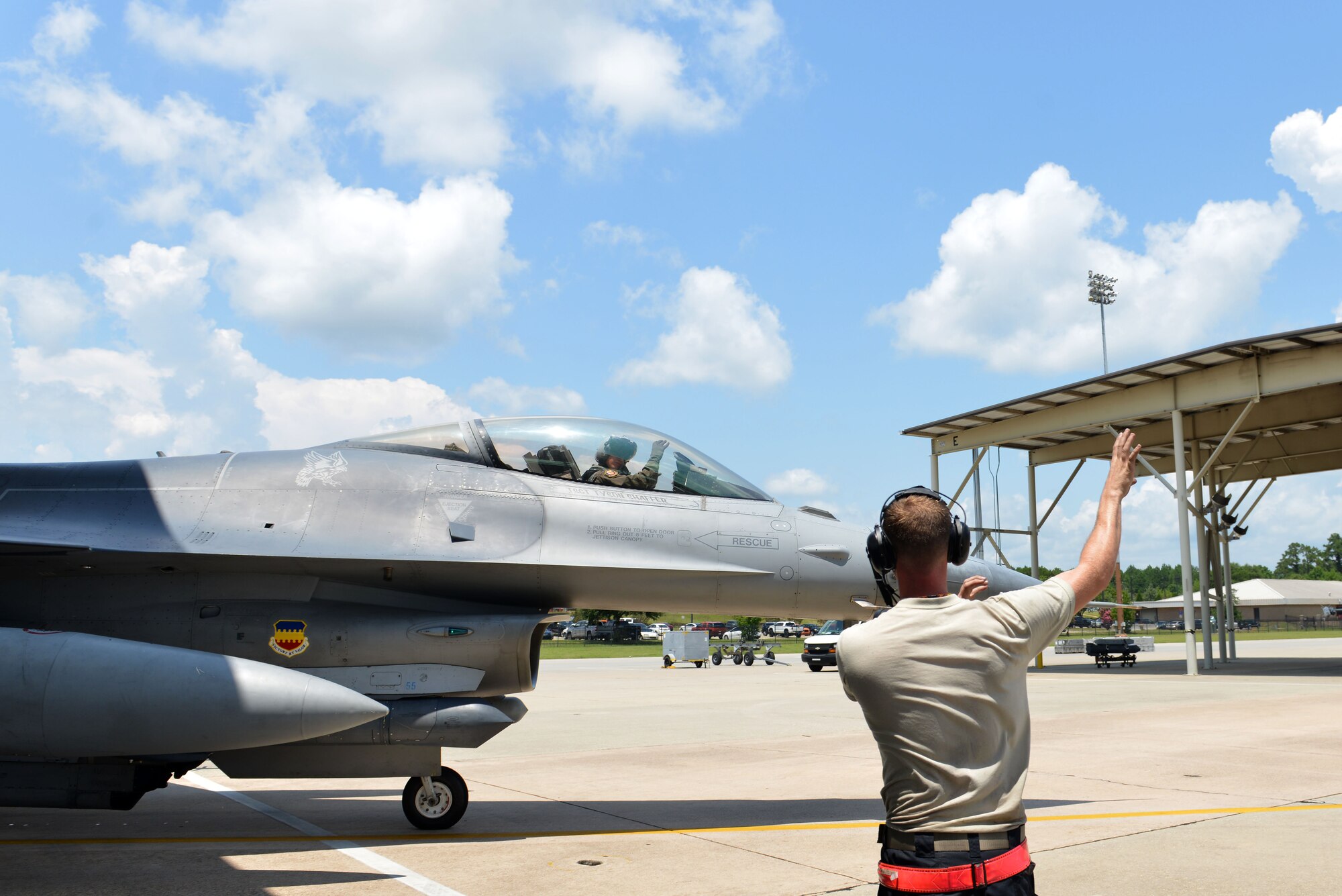 U.S. Air Force Senior Airman John Kelly, 20th Aircraft Maintenance Squadron tactical aircraft maintainer, makes the 79th Fighter Squadron, “Tigers,” hand signal while marshalling out an F-16CM Fighting Falcon at Shaw Air Force Base, S.C., July 19, 2017. The 79th FS is one of three fighter squadrons under the 20th Fighter Wing which provide the suppression of enemy air defenses. (U.S. Air Force photo by Airman 1st Class Destinee Sweeney)