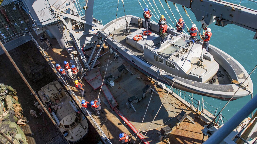 Sailors heave lines to load a landing craft onto the boat deck of the amphibious dock landing ship USS Ashland in the Coral Sea, July 25, 2017, after the completion of Exercise Talisman Saber 2017. Navy photo by Petty Officer 3rd Class Jonathan Clay