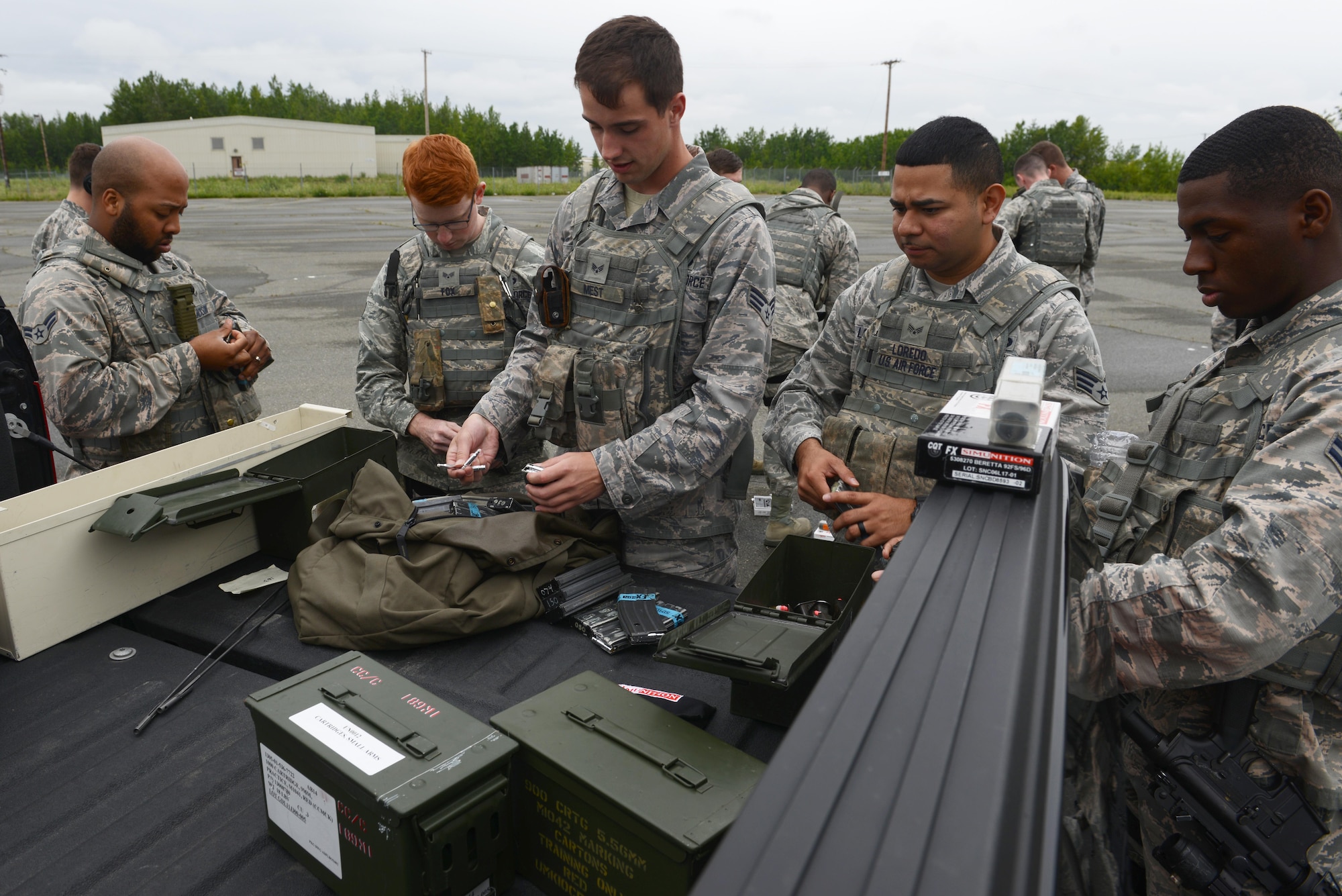 Several 673d Security Forces Squadron members load Simunition marking cartridges in preparation for active-shooter training at Joint Base Elmendorf-Richardson, Alaska, July 18, 2017. All participants were issued proper protective gear, to include a helmet, neck guard and gloves. 