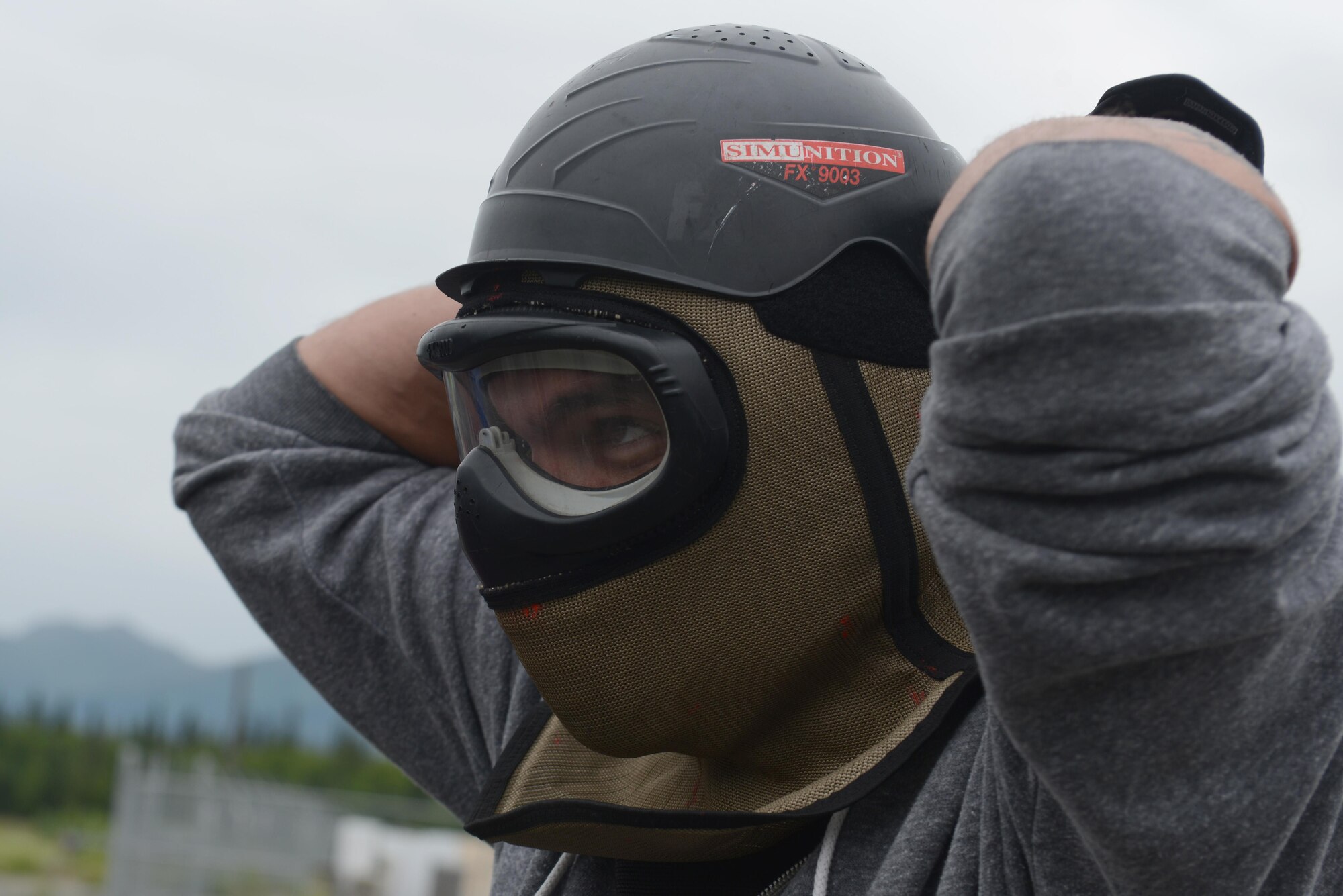 Air Force Staff Sgt. Sean Sullivan, 732nd Aircraft Maintenance Squadron crew chief, dons a protective mask in preparation for 673d Security Forces Squadron active-shooter training at Joint Base Elmendorf-Richardson, Alaska, July 18, 2017. All participants were issued proper protective gear, to include a helmet, neck guard and gloves. 