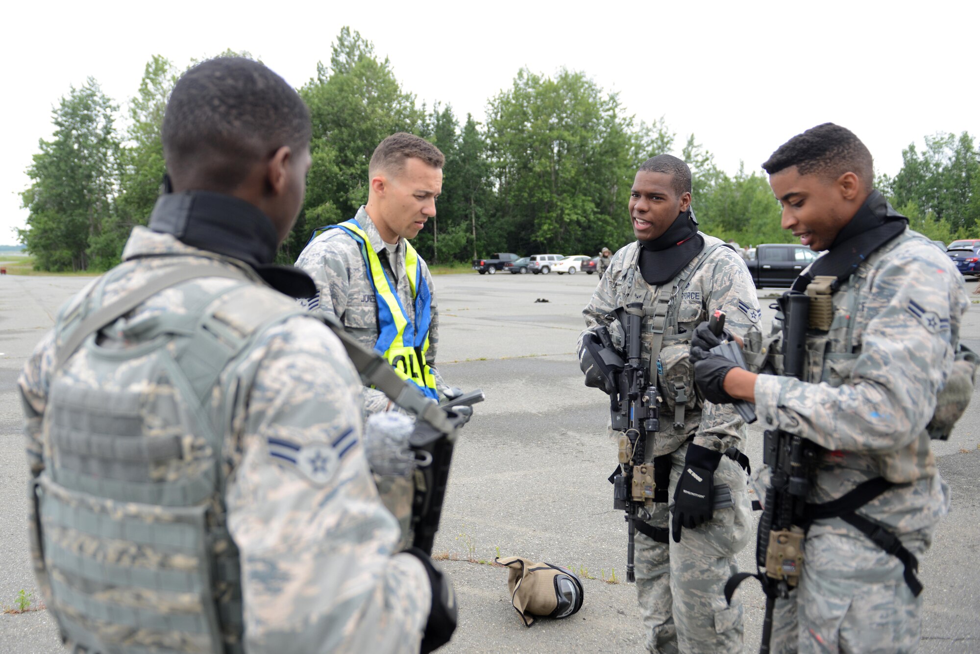 A team of 673d Security Forces Squadron members discuss their actions and responses after going through an active-shooter training scenario at Joint Base Elmendorf-Richardson, Alaska, July 18, 2017. Security forces trained in high-stress environments with hostages and aggressive perpetrators, so they learned how to appropriately respond and handle various hostile situations. 