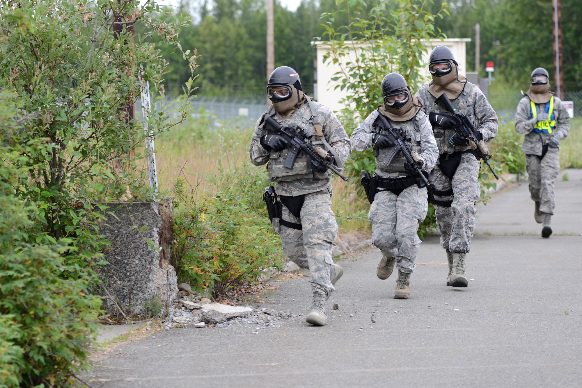 A team of 673d Security Forces Squadron members approach a building during active-shooter training at Joint Base Elmendorf-Richardson, Alaska, July 18, 2017. Security forces trained in high-stress environments with hostages and aggressive perpetrators so they learned how to appropriately respond and handle various hostile situations. 