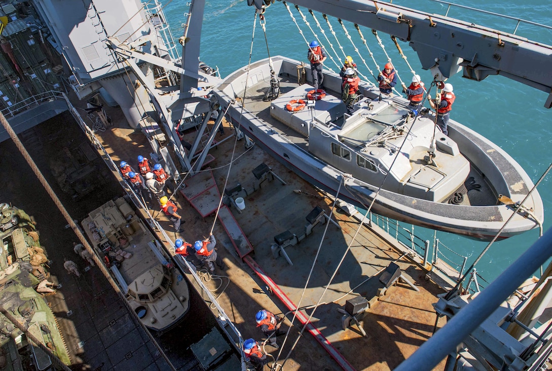 Sailors heave lines to load a landing craft onto the boat deck of the amphibious dock landing ship USS Ashland in the Coral Sea, July 25, 2017, after the completion of Exercise Talisman Saber 2017. Navy photo by Petty Officer 3rd Class Jonathan Clay