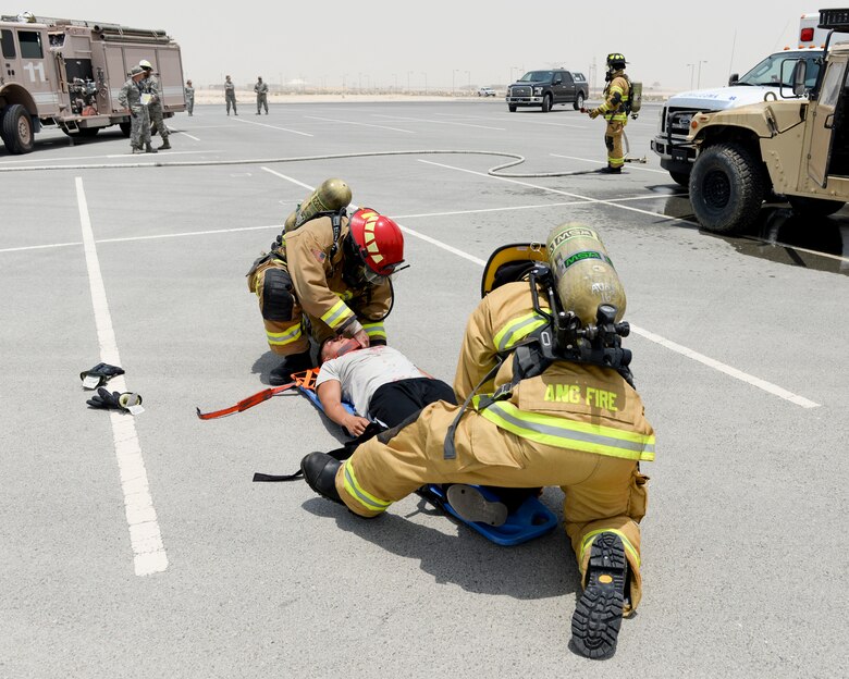 U.S. Air Force fire fighters assigned to the 379th Expeditionary Civil Engineering Squadron, attend to a simulated casualty during a staged automobile accident as part of an exercise at Al Udeid Air Base, Qatar, July 26, 2017. The exercise was designed to test and demonstrate emergency response capabilities available at Al Udeid Air Base.  (U.S. Air National Guard photo by Tech. Sgt. Bradly A. Schneider/Released)