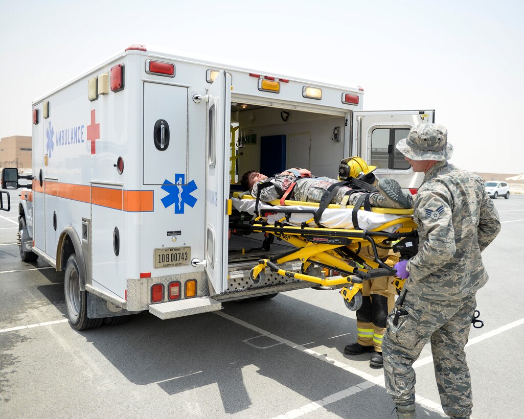 U.S. Air Force Senior Airman Gabriel Weinberg, medical technician assigned to the 379th Expeditionary Medical Squadron assists in loading a simulated casualty into the back of an ambulance during an emergency response exercise at Al Udeid Air Base, Qatar, July 26, 2017. The exercise was designed to test and demonstrate emergency response capabilities available at Al Udeid Air Base. (U.S. Air National Guard photo by Tech. Sgt. Bradly A. Schneider/Released)