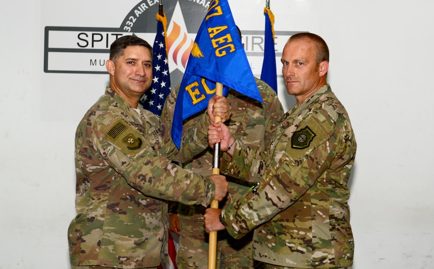 U.S. Air Force Col. John Gonzales, 407th Air Expeditionary Group commander, passes the guidon to Lt. Col. Kristian Thiele, as Thiele assumes command of the 407th Expeditionary Operations Support Squadron July 24, 2017, in Southwest Asia. The passing of the guidon represents a formal transfer of authority and responsibility from an outgoing commander to an incoming one. (U.S. Air Force photo by Tech. Sgt. Andy M. Kin)