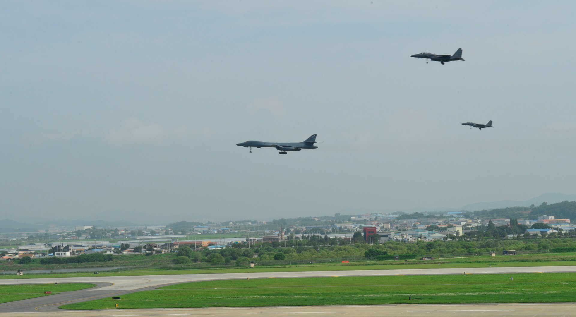 In a demonstration of ironclad U.S. commitment to our allies, two U.S. Air Force B-1B Lancers assigned to the 9th Expeditionary Bomb Squadron, deployed from Dyess Air Force Base, Texas, perform a low pass over Osan Air Base, Republic of Korea, during a 10-hour mission from Andersen Air Force Base, Guam, into Japanese airspace and over the Korean Peninsula, July 30, 2017. The B-1s first made contact with Japan Air Self-Defense Force F-2 fighter jets in Japanese airspace, then proceeded over the Korean Peninsula and were joined by South Korean F-15 fighter jets. This mission is in direct response to North Korea’s escalatory launch of intercontinental ballistic missiles on July 3 and 28.  (U.S. Air Force photo/Tech. Sgt. Benjamin Wiseman)