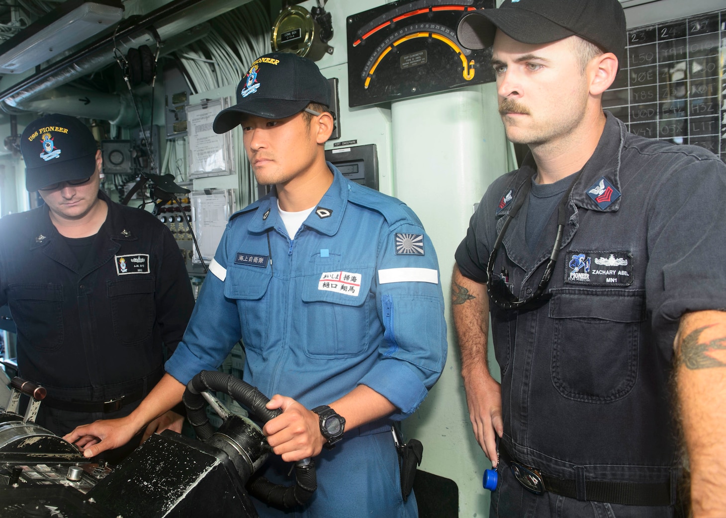 MUTSU, Japan (July 26, 2017) — Petty Officer Third Class Higuchi Shoma, Japanese Maritime Self Defense Force (JMSDF), center, pilots USS Pioneer during 2JA 2017 Mine Countermeasures Exercise (2JA-17 MCMEX) as Mineman First Class Zachary Abel, right, observes. 2JA Mine Countermeasures Exercise is an annual bilateral exercise held between the U.S. Navy and JMSDF to strengthen interoperability and increase proficiencies in mine countermeasure operations.