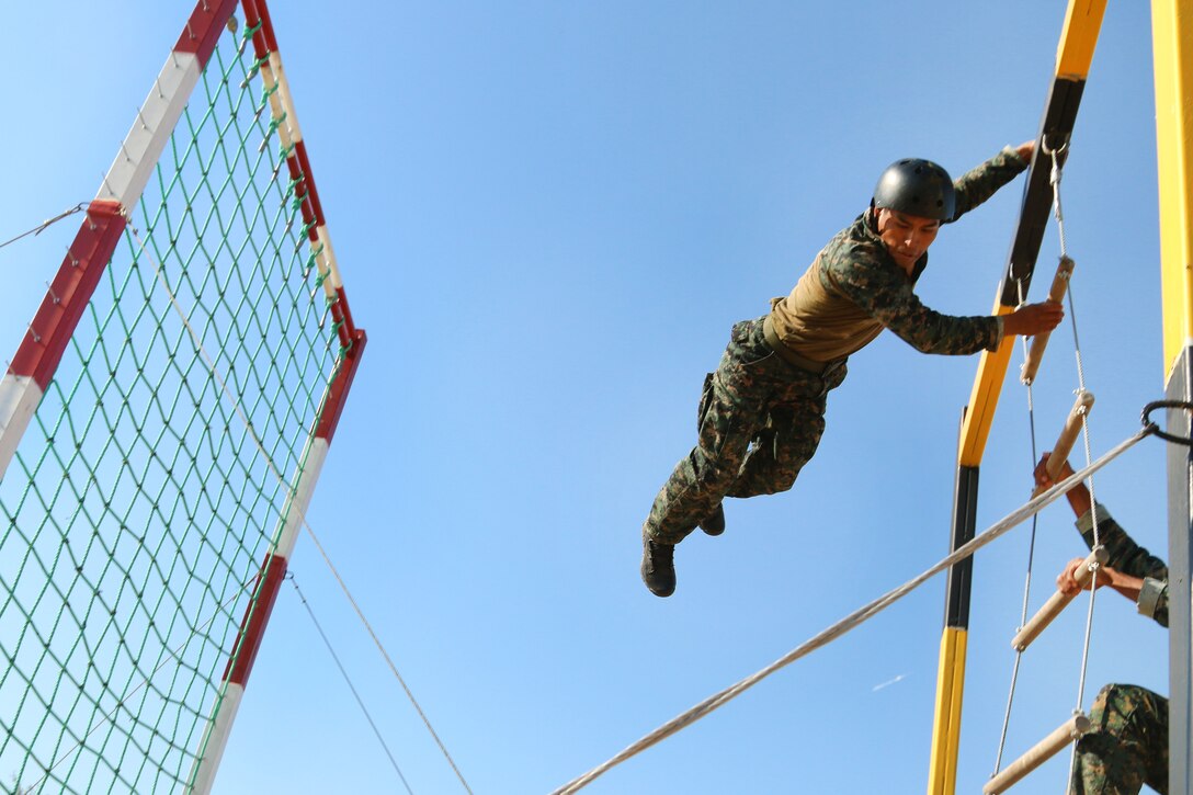 A member of the Peruvian special operations team swings over the top bar of a ladder obstacle during Fuerzas Comando 2017 in Vista Alegre, Paraguay, July 24, 2017. Army photo by Staff Sgt. Chad Menegay