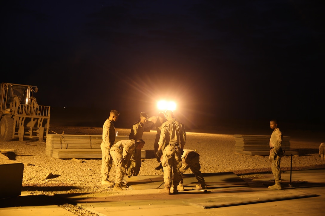 U.S. Marines attached to Task Force Al Asad with Marine Wing Support Squadron (MWSS) 372, Special Purpose Marine Air-Ground Task Force-Crisis Response-Central Command, lay expeditionary airfield matting in support of engineering operations at Al Asad Air Base, Iraq, July 7, 2017. The Marines of the Engineering Detachment work daily on a variety of engineer tasks in support of the master base plan for Task Force Al Asad. Task Force Al Asad’s mission is to advise and assist   and build partner capacity with the Iraqi Security Forces in Al Anbar province in support of Combined Joint Task Force-Operation Inherent Resolve, the global coalition to defeat ISIS in Iraq and Syria. (U.S. Marine Corps photo by 1st Lt. Dave Williams)