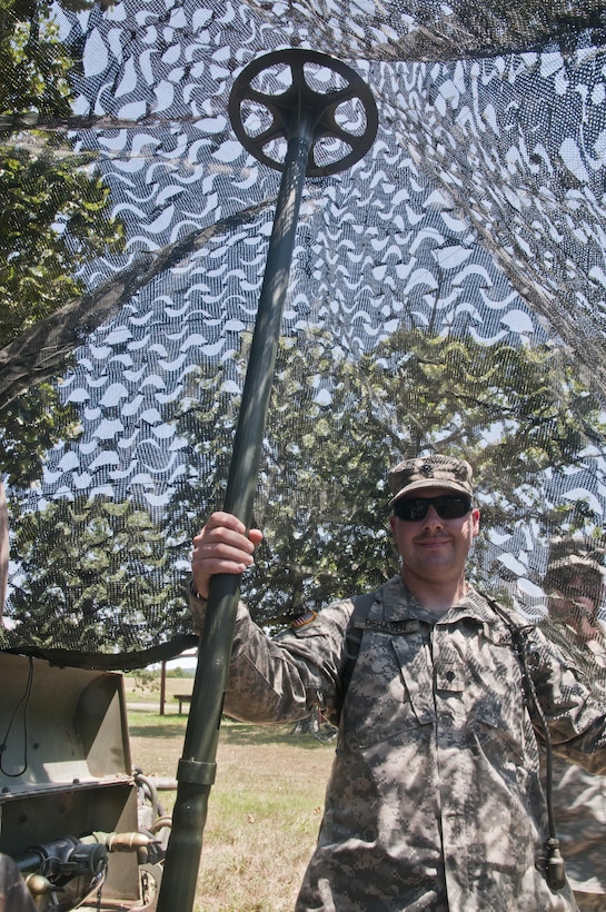 Spc. Sam Dehaven, a U.S. Army Reserve medic and civilian commercial window installer with the 844th HHC, Engineer Battalion, 411th Engineer Brigade, 412th Theater Engineer Command, sets up camo netting at the 844th's familiarize fire for the new M320 40mm grenade launcher during River Assault 2017 at Fort Chaffee Maneuver Center, Ark., July 24, 2017. River Assault 2017 is a two-week extended combat training exercise held July 15-28 focusing on technical skills, of various service members, culminating with the construction of a floating improved ribbon bridge across the Arkansas River.  (U.S. Army Reserve Photo by Staff Sgt. Roger Ashley)