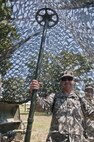 Spc. Sam Dehaven, a U.S. Army Reserve medic and civilian commercial window installer with the 844th HHC, Engineer Battalion, 411th Engineer Brigade, 412th Theater Engineer Command, sets up camo netting at the 844th's familiarize fire for the new M320 40mm grenade launcher during River Assault 2017 at Fort Chaffee Maneuver Center, Ark., July 24, 2017. River Assault 2017 is a two-week extended combat training exercise held July 15-28 focusing on technical skills, of various service members, culminating with the construction of a floating improved ribbon bridge across the Arkansas River.  (U.S. Army Reserve Photo by Staff Sgt. Roger Ashley)