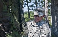Cpl. Brandon Kitts, a U.S. Army Reserve combat engineer and civilian architectual draftsman with the 844th HHC, Engineer Battalion, 411th Engineer Brigade, 412th Theater Engineer Command, sets up camo netting at the 844th's familiarize fire for the new M320 40mm grenade launcher during River Assault 2017 at Fort Chaffee Maneuver Center, Ark., July 24, 2017. River Assault 2017 is a two-week extended combat training exercise held July 15-28 focusing on technical skills, of various service members, culminating with the construction of a floating improved ribbon bridge across the Arkansas River.  (U.S. Army Reserve Photo by Staff Sgt. Roger Ashley)
