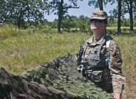 Pfc. Katy Richardson, a U.S. Army Reserve human resources Soldier and social work college student from Knoxville Tenn., with the 844th HHC, Engineer Battalion, 411th Engineer Brigade, 412th Theater Engineer Command, sets up camo netting at the 844th's familiarize fire for the new M320 40mm grenade launcher during River Assault 2017 at Fort Chaffee Maneuver Center, Ark., July 24, 2017. River Assault 2017 is a two-week extended combat training exercise held July 15-28 focusing on technical skills, of various service members, culminating with the construction of a floating improved ribbon bridge across the Arkansas River.  (U.S. Army Reserve Photo by Staff Sgt. Roger Ashley)