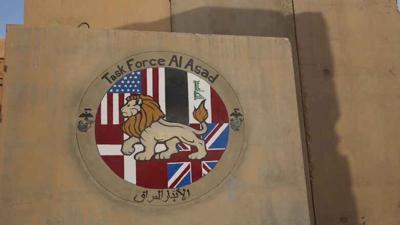 Task Force Al Asad’s logo is displayed on a concrete barrier in front of the Task Force Headquarters at Al Asad Air Base, Iraq, July 8, 2017. The Task Force, in its fourth iteration, was stood up in 2015 and comprises of coalition forces including the U.S., British, and Danish Armies. Task Force Al Asad’s mission is to advise and assist and build partner capacity with the Iraqi Security Forces in Al Anbar province in support of Combined Joint Task Force-Operation Inherent Resolve, the global coalition to defeat ISIS in Iraq and Syria. (U.S. Marine Corps photo by 1st Lt. Dave Williams)