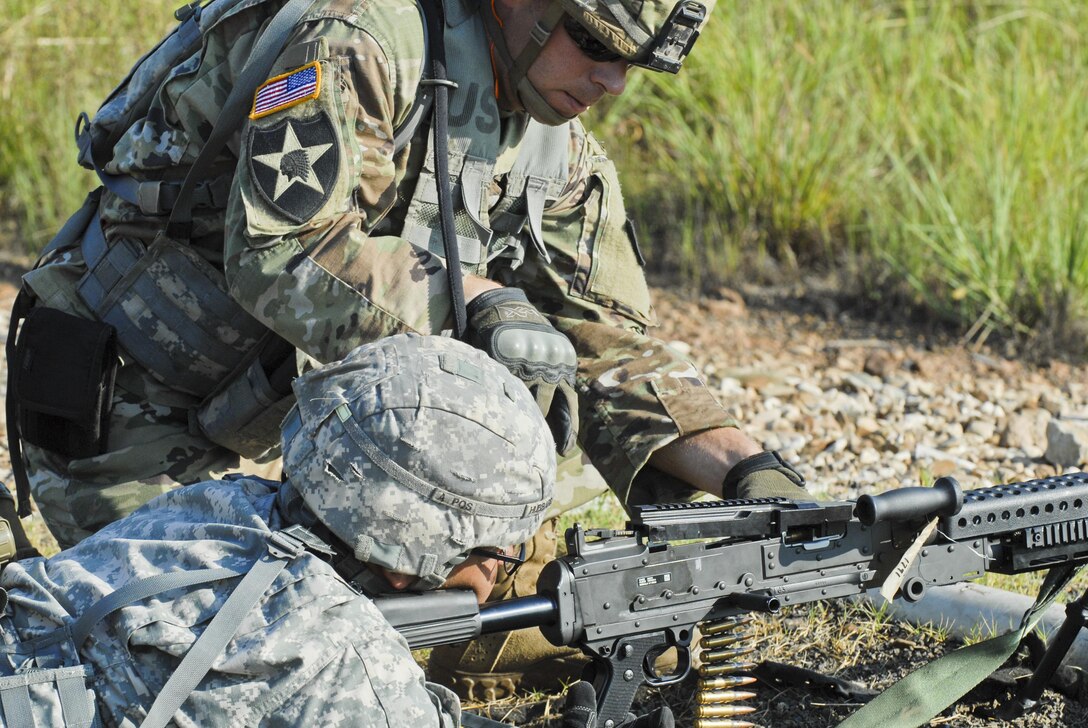 Sgt. Ryan Wells belt feeds Spc. John Hubbard's M240. Wells and Hubbard are U.S. Army Reserve Soldiers with the 463rd FSC, Engineer Battalion, 411th Engineer Brigade, 412th Theater Engineer Command, preparing for a familiarization and qualify fire with the M240 machine gun during River Assault 2017 at Fort Chaffee Maneuver Center, Ark., July 25, 2017. River Assault 2017 is a two-week extended combat training exercise held July 15-28 focusing on technical skills, of various service members, culminating with the construction of a floating improved ribbon bridge across the Arkansas River.  (U.S. Army Reserve Photo by Staff Sgt. Roger Ashley)