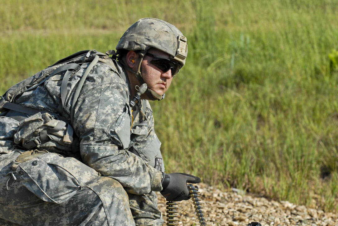 Spc. Richard Black, a U.S. Army Reserve Soldier with the 463rd FSC, Engineer Battalion, 411th Engineer Brigade, 412th Theater Engineer Command, feeds rounds to a shooter during a familiarization and qualify fire with the M240 machine gun and M249 Squad Automatic Weapon during River Assault 2017 at Fort Chaffee Maneuver Center, Ark., July 25, 2017. River Assault 2017 is a two-week extended combat training exercise held July 15-28 focusing on technical skills, of various service members, culminating with the construction of a floating improved ribbon bridge across the Arkansas River.  (U.S. Army Reserve Photo by Staff Sgt. Roger Ashley)