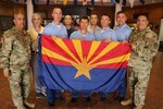 Command Sgt. Major Fidel Zamora, the senior enlisted advisor for the Arizona Army National Guard and Command Sgt. Major Saul Garcia, the command sergeant major for the 98th Aviation Troop Command, hold the Arizona state flag with delegates from Kazakhstan during a visit to exchange aviation maintenance practices and non-commissioned officer development July 25, 2017. The visit came within weeks of the U.S. government’s formal renewal of its partnership with Kazakhstan, extending the 24-year-old legacy of cooperation for five more years. 