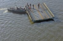 A MKII Bridge Erection Boat pushes an Improved Ribbon Bridge (IRB) Bay Section down the Arkansas River during River Assault 2017 on Fort Chaffee Manuever Training Center, July 26, 2017. The Bay was among several that formed a IRB across the river, the culminating event of River Assault. Operation River Assault is one of the key training events that demonstrates that America’s Army Reserve is the most capable, combat ready, and lethal Federal Reserve Force in the history of the nation. (U.S. Army Reserve Photo by Sgt. 1st Class Clinton Wood)