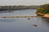 MKII Bridge Erection Boats position against the current Improved Ribbon Bridge (IRB) Bay Sections across the  Arkansas River during River Assault 2017 on Fort Chaffee Manuever Training Center, July 26, 2017. The estimated 300-meter IRB across the river was the culminating event of River Assault. Operation River Assault, July 26, 2017. Operation River Assault is one of the key training events that demonstrates that America’s Army Reserve is the most capable, combat ready, and lethal Federal Reserve Force in the history of the nation. (U.S. Army Reserve Photo by Sgt. 1st Class Clinton Wood)
