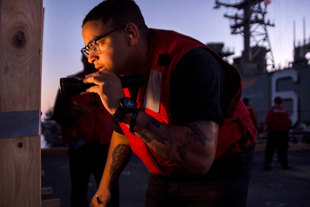 Navy Seaman Robert Littlejohn scores the number of hits on a firing-range target during a low light gun shoot aboard the amphibious assault ship USS Bonhomme Richard in the Coral Sea, July 28, 2017. Littlejohn is a gunner’s mate. The Bonhomme Richard is working to enhance partnerships in the Indo-Asia-Pacific region. Navy photo by Seaman Apprentice Gavin Shields