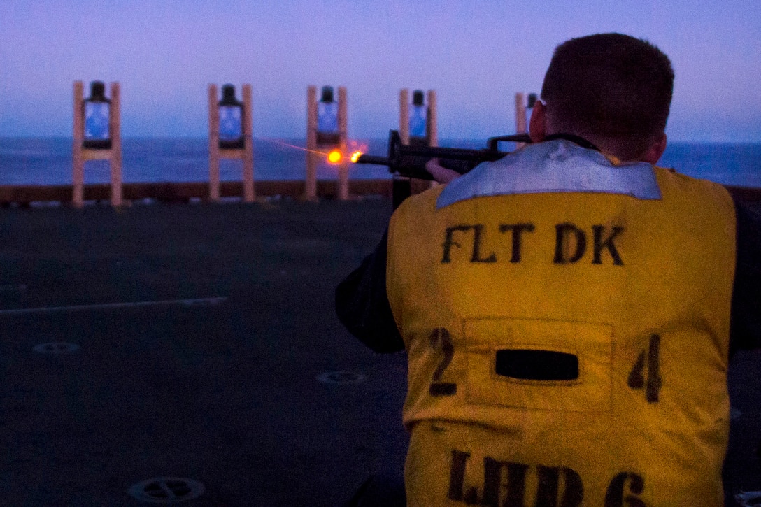 Navy Petty Officer 2nd Class Christopher Love fires an M16 rifle during a low light gun shoot aboard the amphibious assault ship USS Bonhomme Richard in the Coral Sea, July 28, 2017. Love is a fire controlman. Navy photo by Seaman Apprentice Gavin Shields