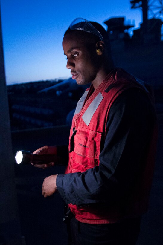 Navy Petty Officer 3rd Class Yusef Reynolds scores the number of hits on a firing-range target during a low light gun shoot aboard the amphibious assault ship USS Bonhomme Richard in the Coral Sea, July 28, 2017. Reynolds is a gunner’s mate. Navy photo by Seaman Apprentice Gavin Shields 